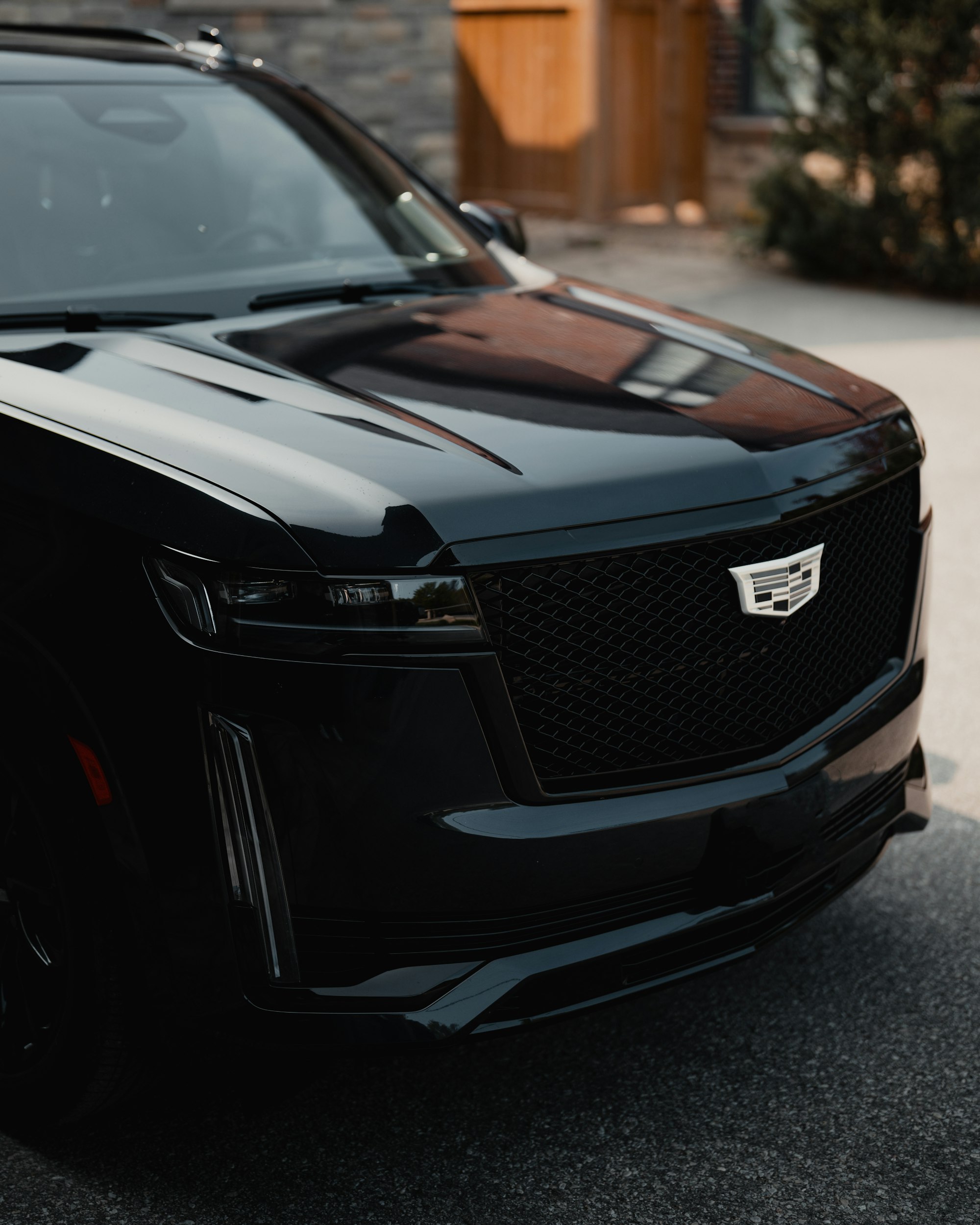 Close-up of a black luxury SUV front grille and headlight